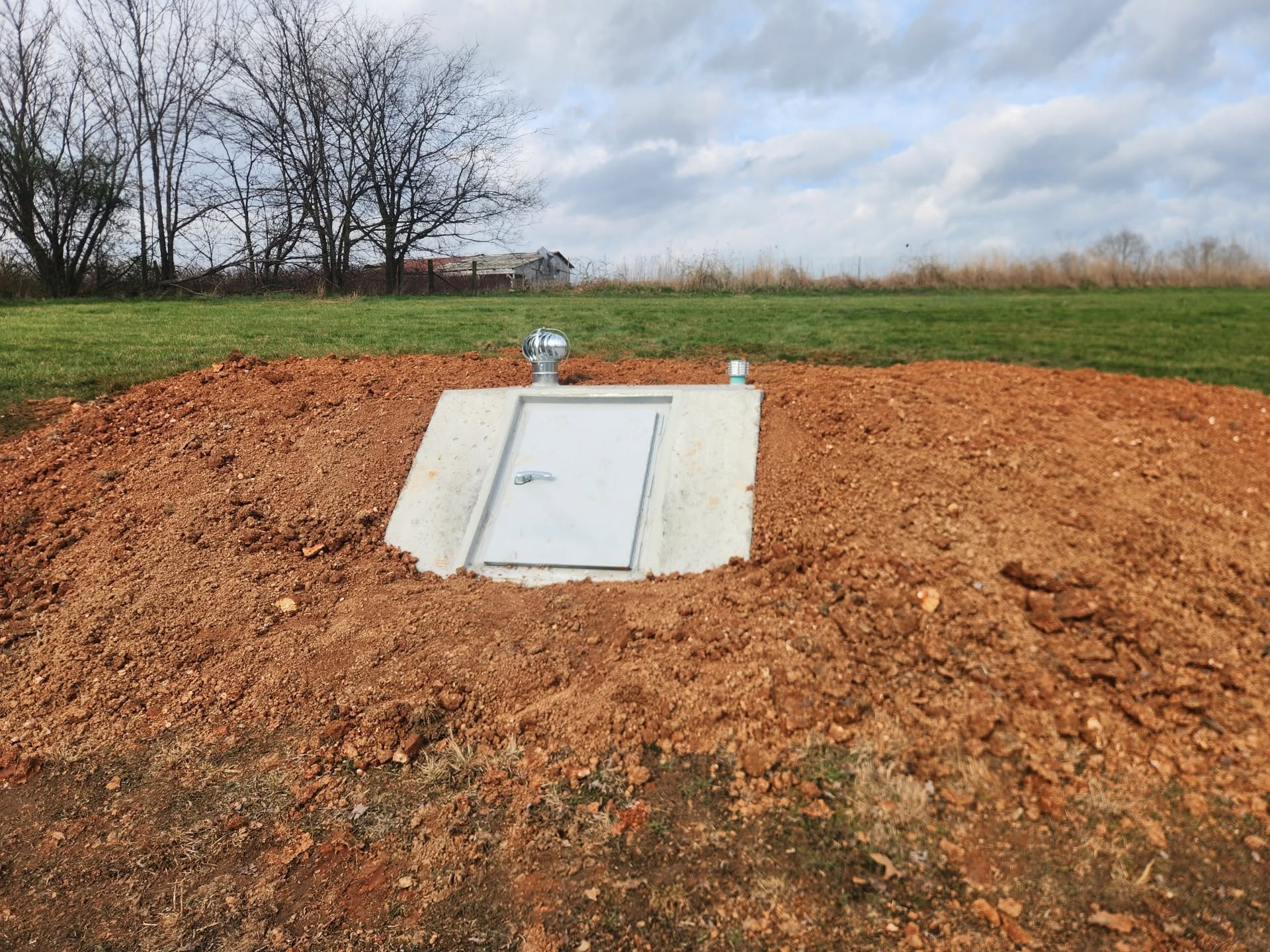 Completed underground concrete storm shelter installation in rural Kentucky